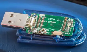 Rozłożony pendrive z widoczną zieloną płytką drukowaną i metalowym złączem USB.