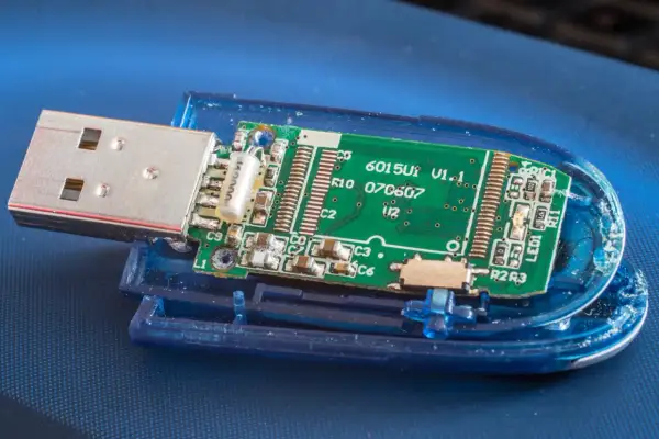 Rozłożony pendrive z widoczną zieloną płytką drukowaną i metalowym złączem USB.